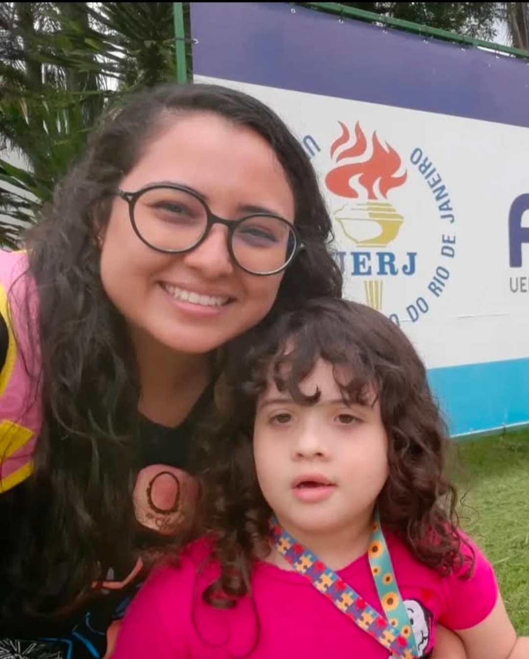 Kezia Queiroz ao lado de sua filha Luísa, em frente à FEBF/UERJ-Caxias